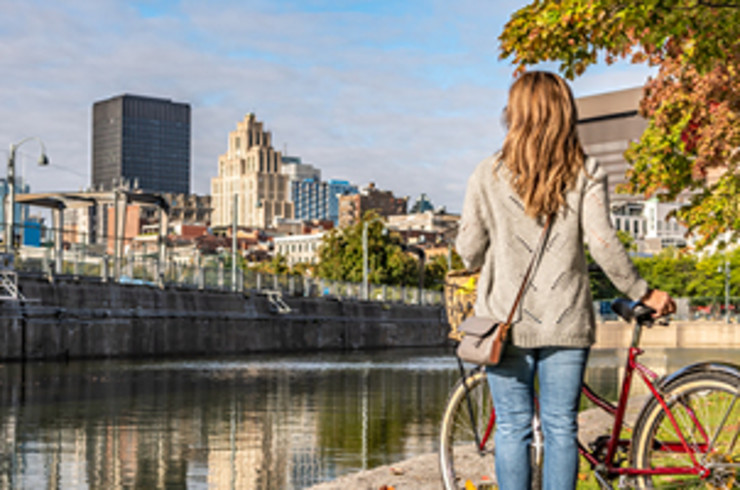 lady holding bike looking towards montreal city