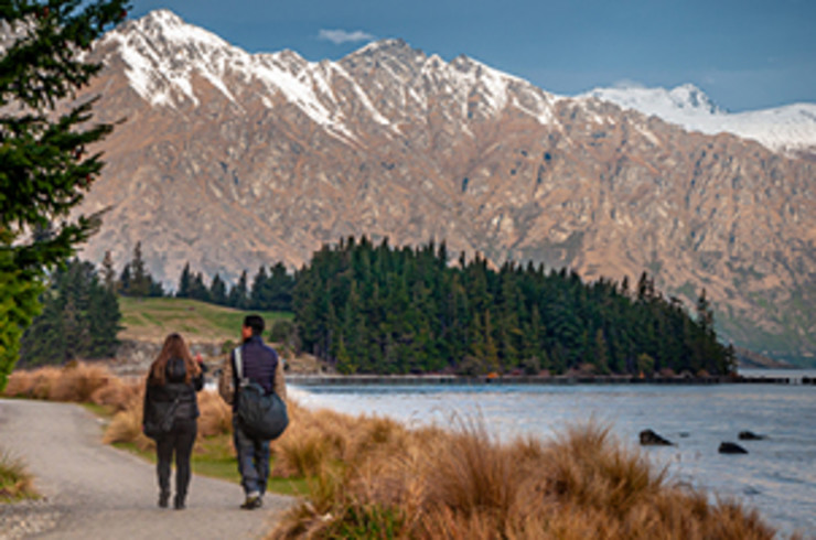 Walking past lake with snowcapped mountains in the background