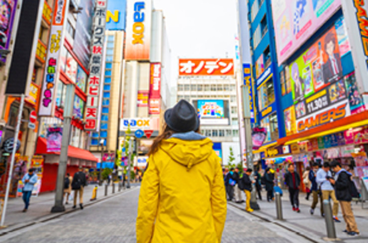 Lady standing in yellow jacket in the middle of Tokyo's Akihabara district
