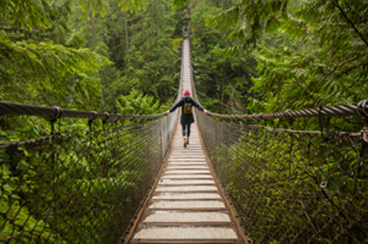 Woman crossing a rope bridge