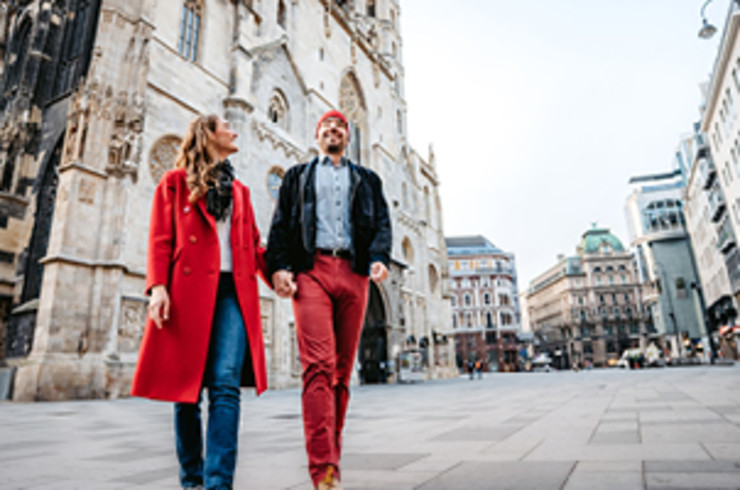 couple holding hands and walking through city in vienna