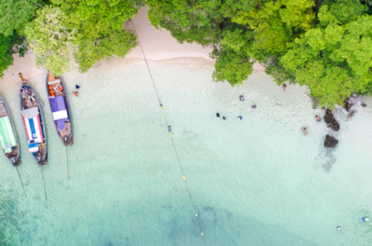 phuket beach surrounded by rocks and trees