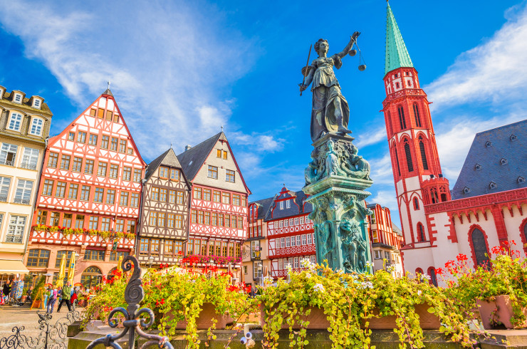 Romerberg city square in Frankfurt - brightly coloured Bavarian buildings and a statue of justice