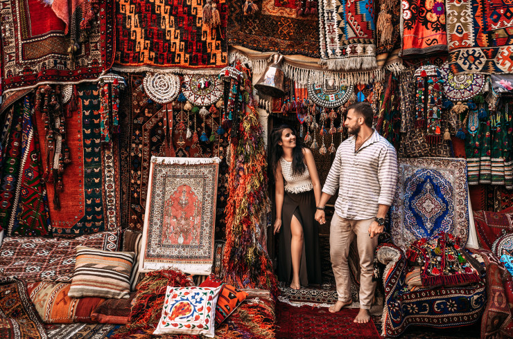 Couple smiling while browsing a carpet bazar in Istanbul