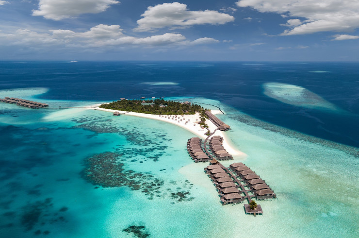 Overhead shot of multiple bungalows and a sandy island