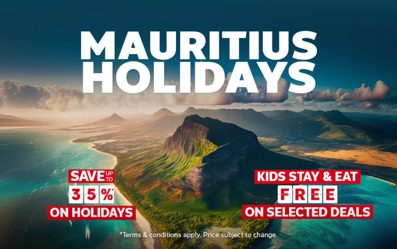 Aerial view of Mauritius with dramatic mountain peaks and turquoise lagoons featuring holidays saving up to 35% and kids stay and eat free