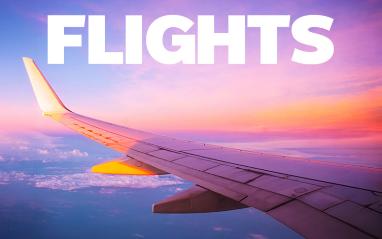 Flights - wing of a plane flying at sunset