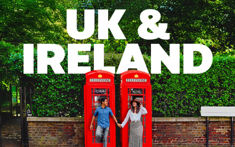 UK & Ireland - couple holding hands in front of red phonebooths in the UK