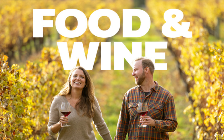 Food & Wine - couple walking through a vineyard, drinking wine