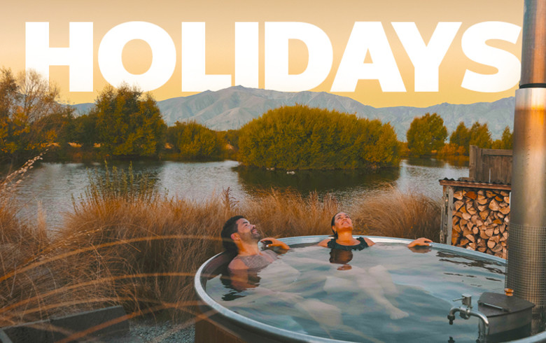 Holidays - people relaxing in a hot tub with the New Zealand bush in the background