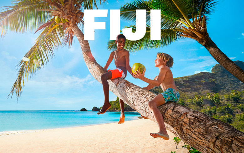 Fiji | Two kids playing on a palm tree on a beach