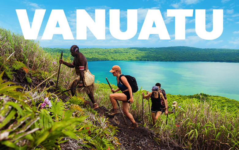 Vanuatu | Hikers walking up a trail on a tropical island with a large lake in the background