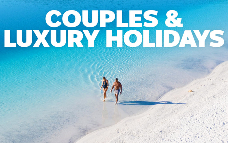 Couples & luxury holidays | wide shot of two people walking at the beach