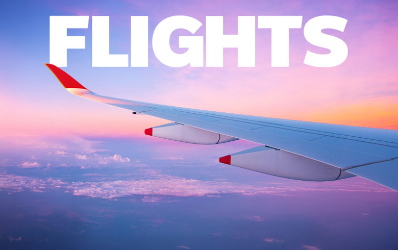 Flights - wing of a plane flying at sunset