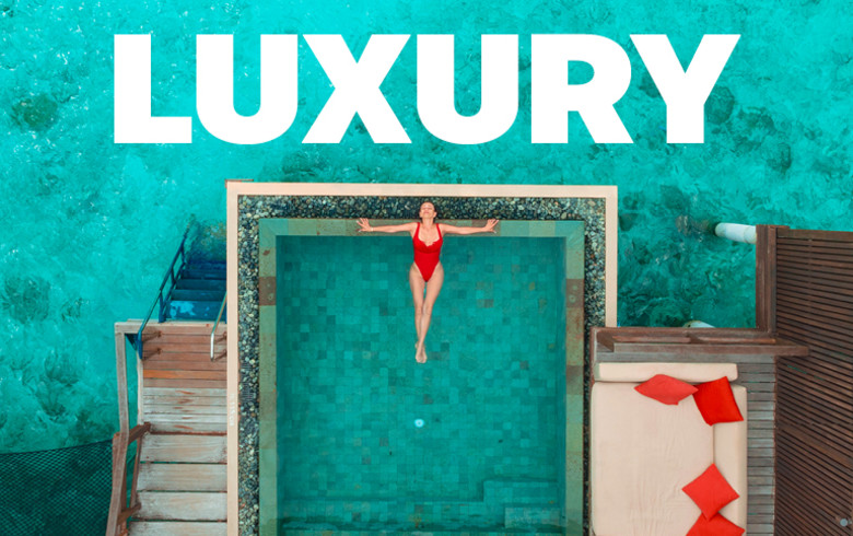 Luxury - top down view of a woman relaxing in a pool over the ocean