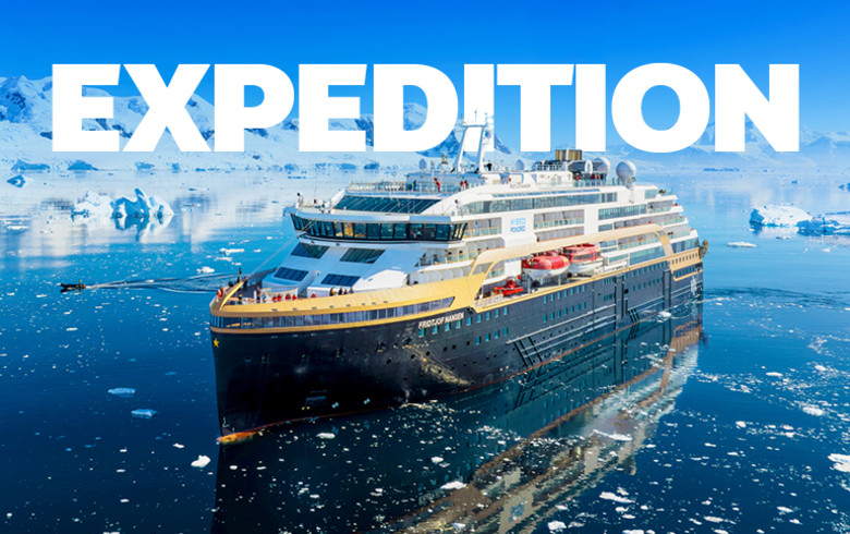 Expedition cruise ship sailing through icy Antarctic waters surrounded by icebergs and snow capped mountains