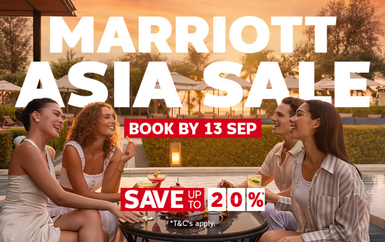 Four young adults dressed in white drinking cocktails next to a hotel pool featuring a Marriott Asia sale with savings up to 20%