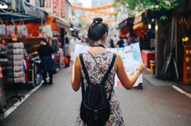 lady holding map walking down street in singapore