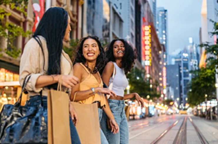 Three friends shopping in Sydney, crossing the tram tracks