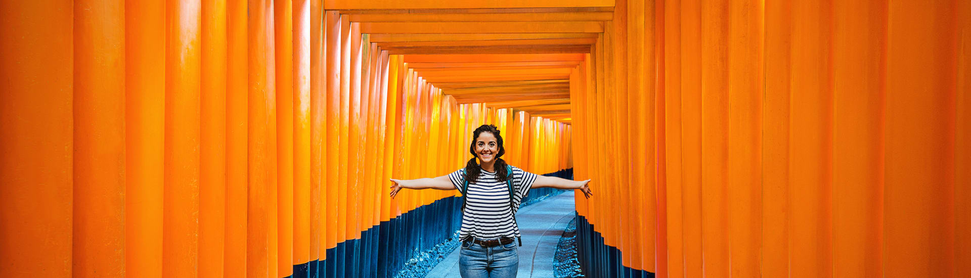 Woman posing in a tunnel of Torii gates