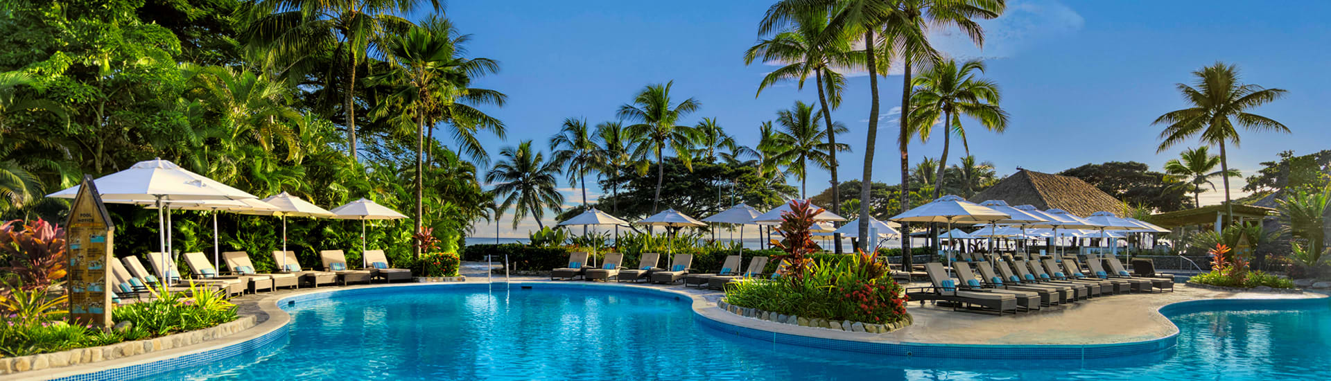 image of pool surrounded by lounge chairs and trees