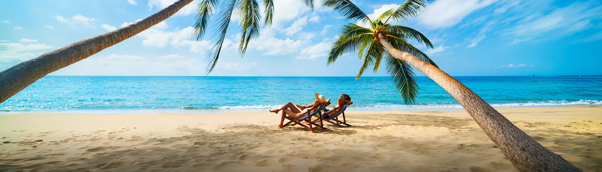Two people relaxing on chairs on a secluded beach
