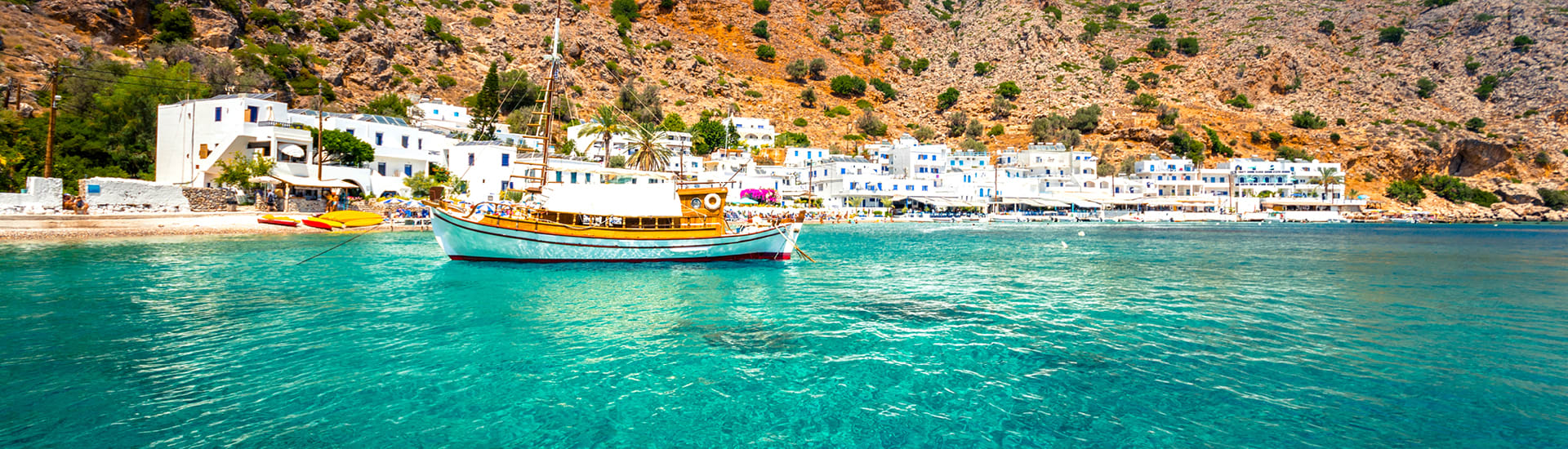 A view of Greek beach and mountain regarding an international holiday package.