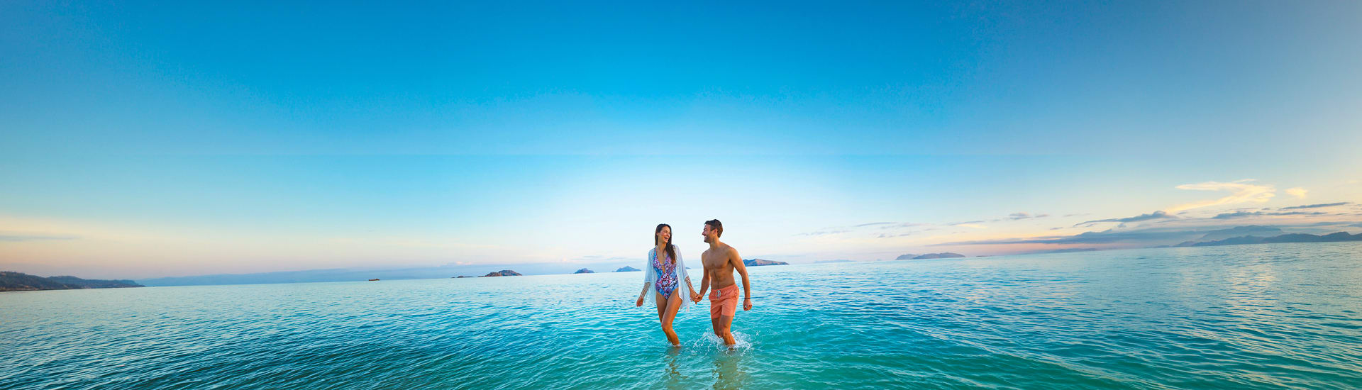 A couple in the water holding hands