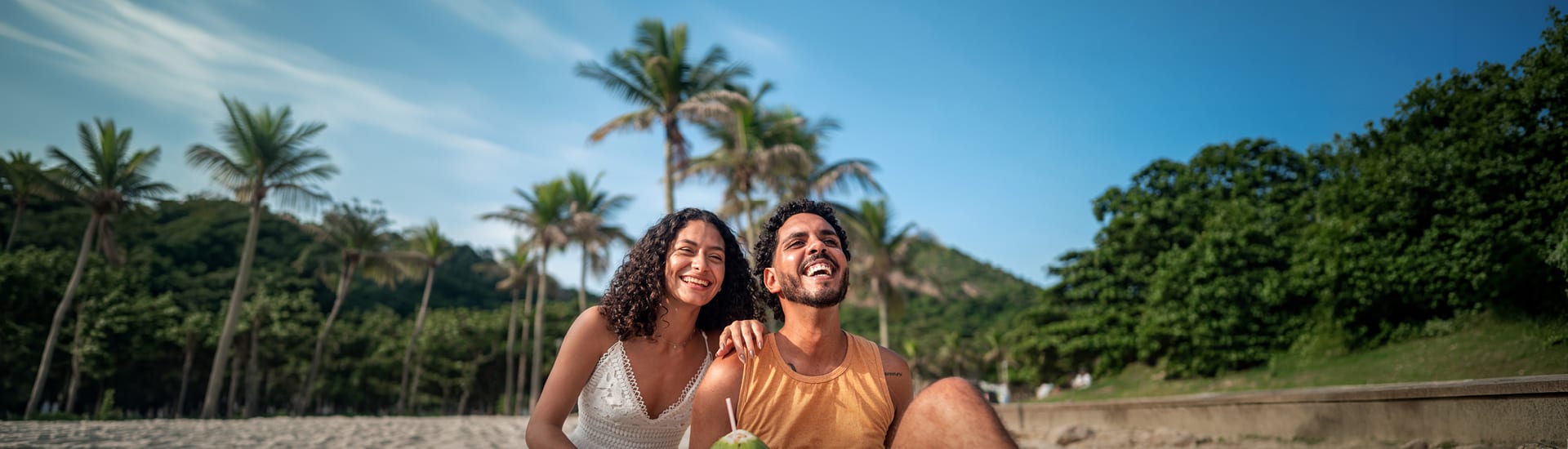A couple with big smiles on a tropical beach