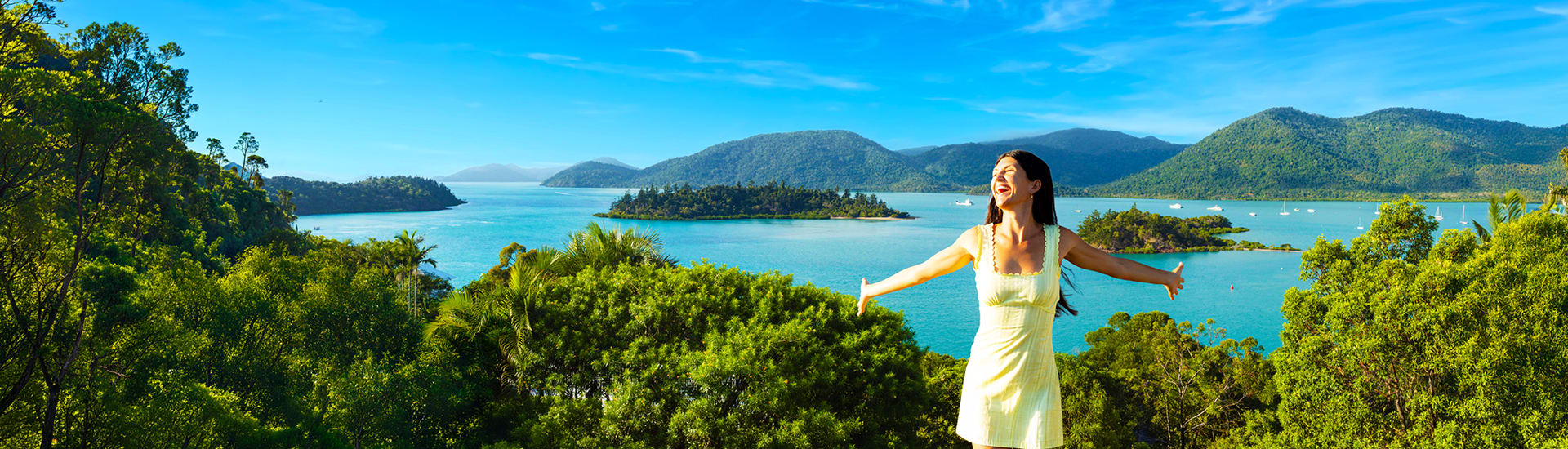 Woman cheering with her arms outstretched, with islands in the background