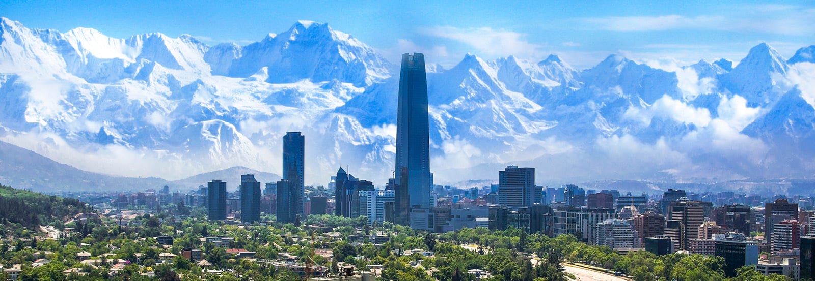 Panorama of Compostela with greenery at the bottom, skyscrapers in the center of shot and snowy mountains in the background
