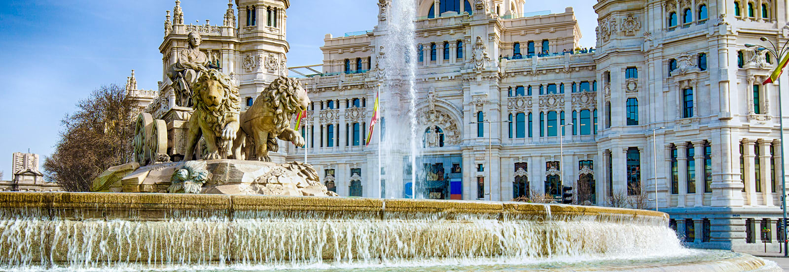 Close up of the lions on the Cibeles Fountain with palace in background