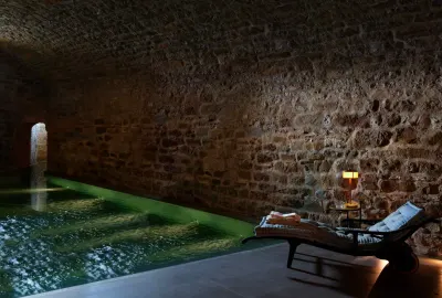 The Roman bath, warm saltwater under candlelit stone vaults. Credit: Reschio