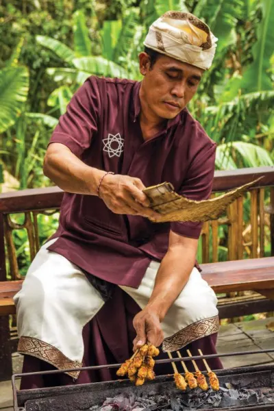 A man cooking satays