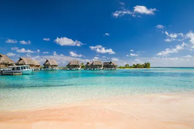 The famous pink sand beach of Tikehau Island, with bungalows in background