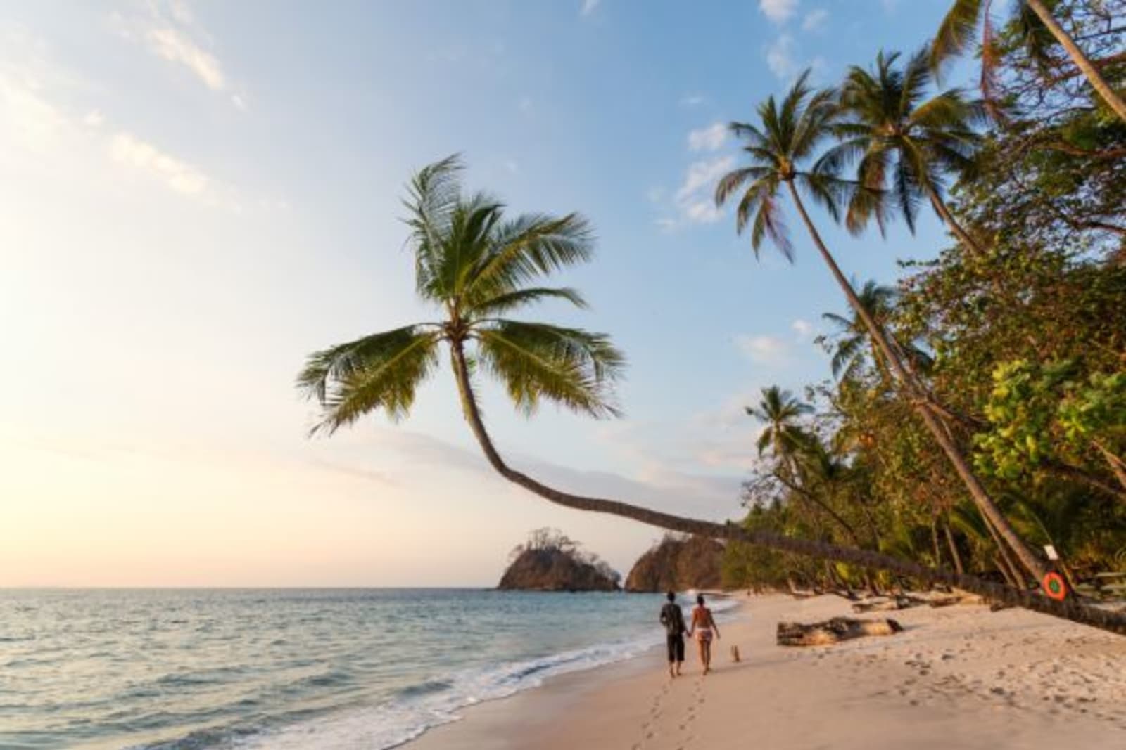 A couple walks along a tropical beach in Costa Rica