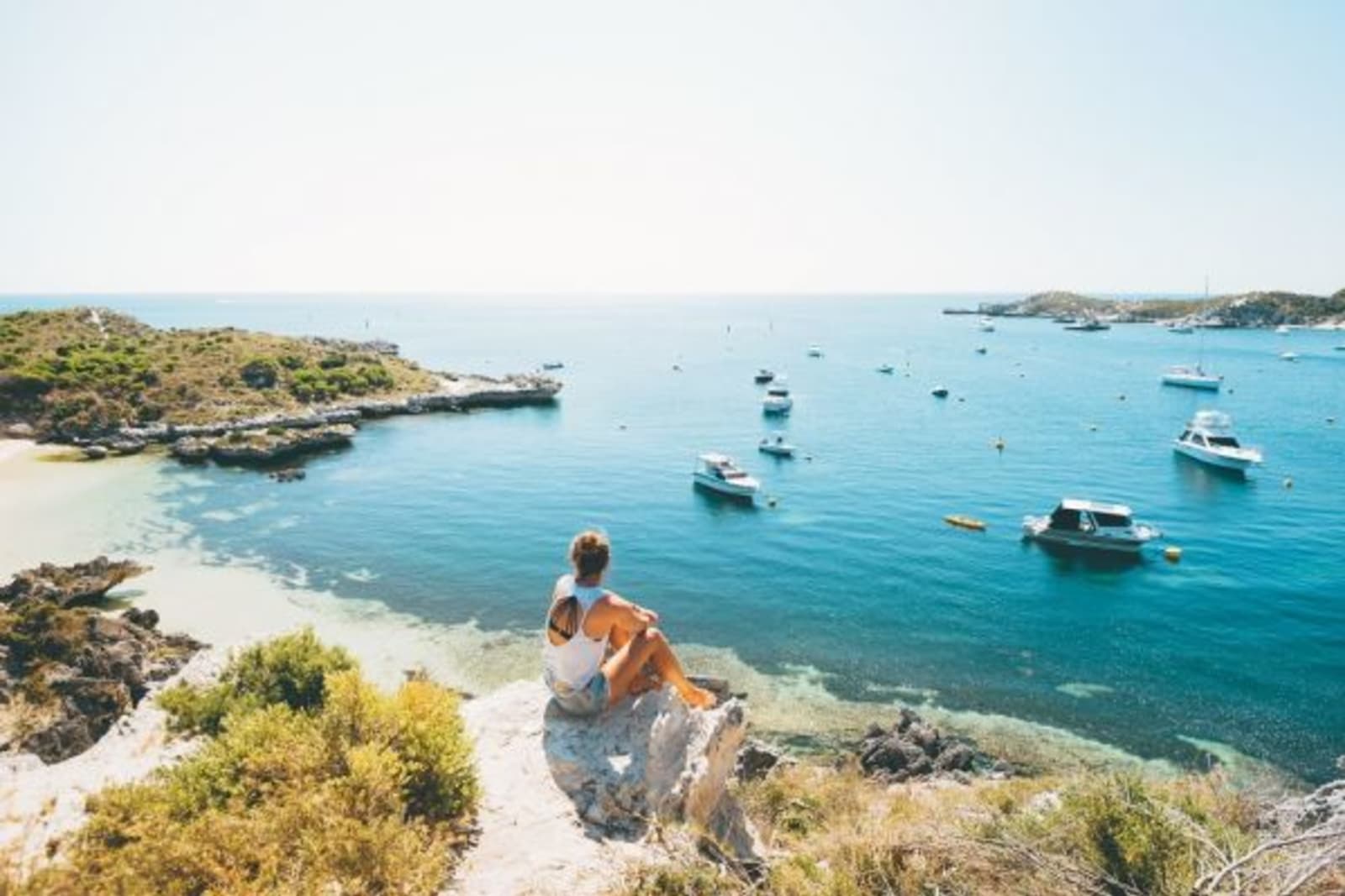Woman overlooking boats in the water floating during the day