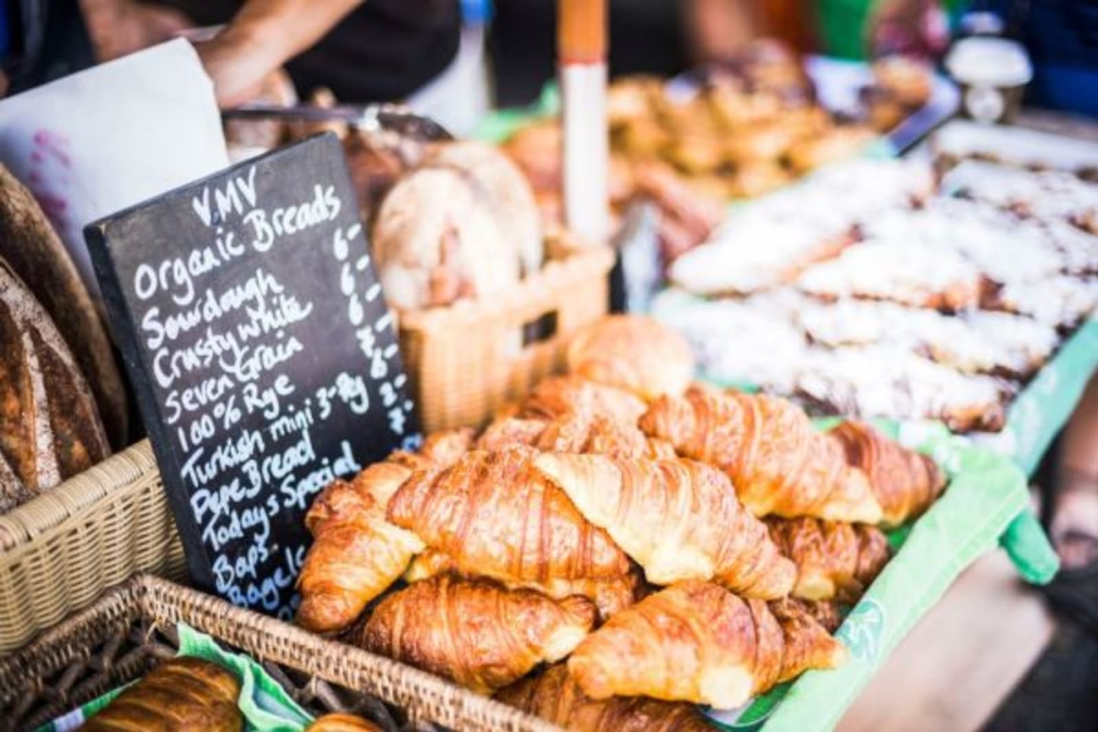 Food market with pastries on sale and a blackboard outlining the food available