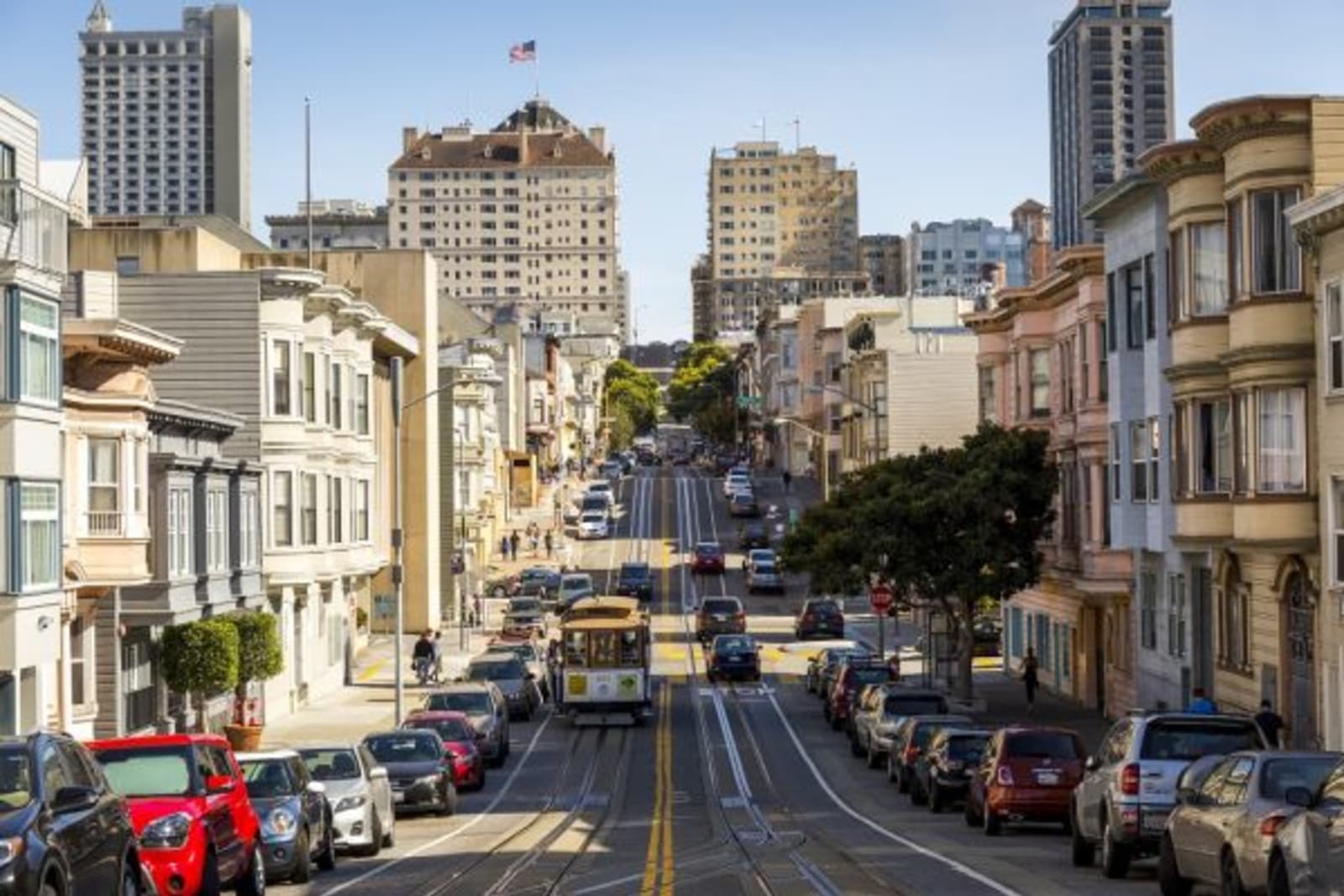 Cable car and cars going through the city of San Francisco