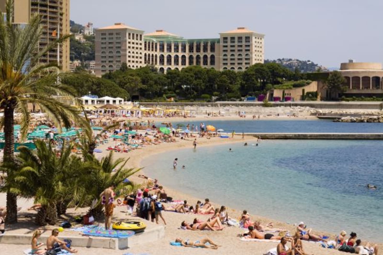Popular beach with people sunbaking and swimming