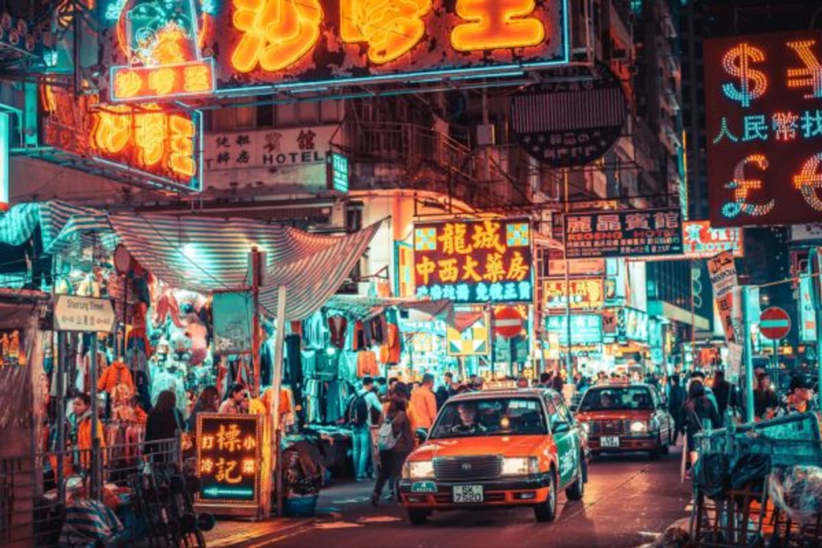 Street signs lite up as cars drive past in downtown Kowloon