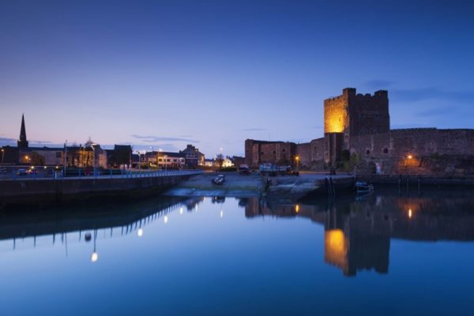 Building reflection and lights on riverbank and boat ramp in Belfast