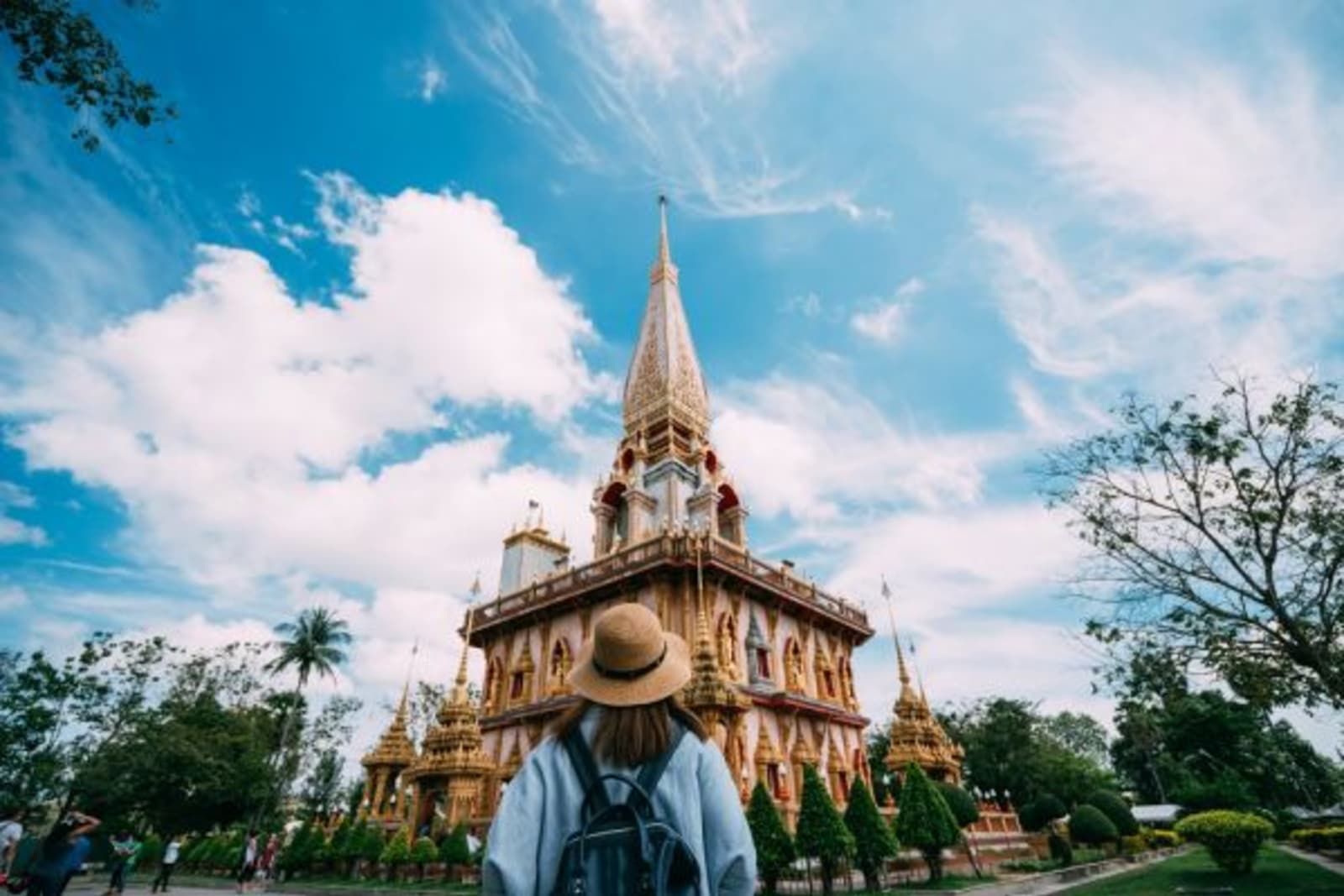 Woman looking up at an ancient temple in Phuket