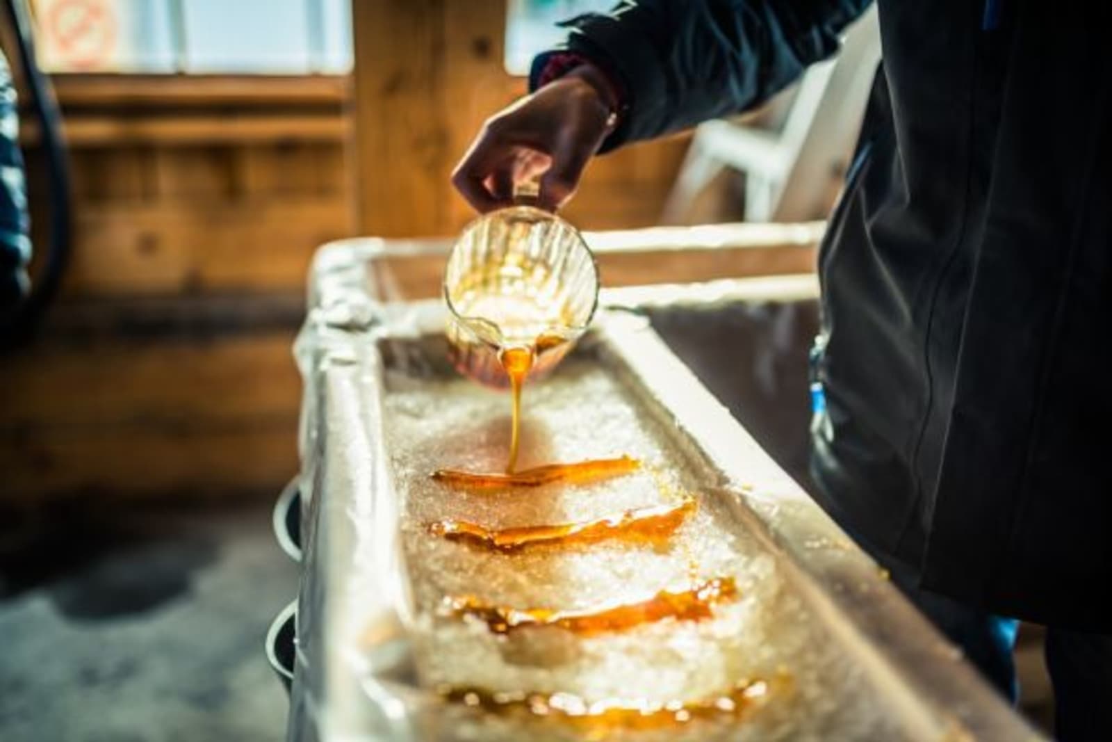 Person pouring liquid substance on sugar