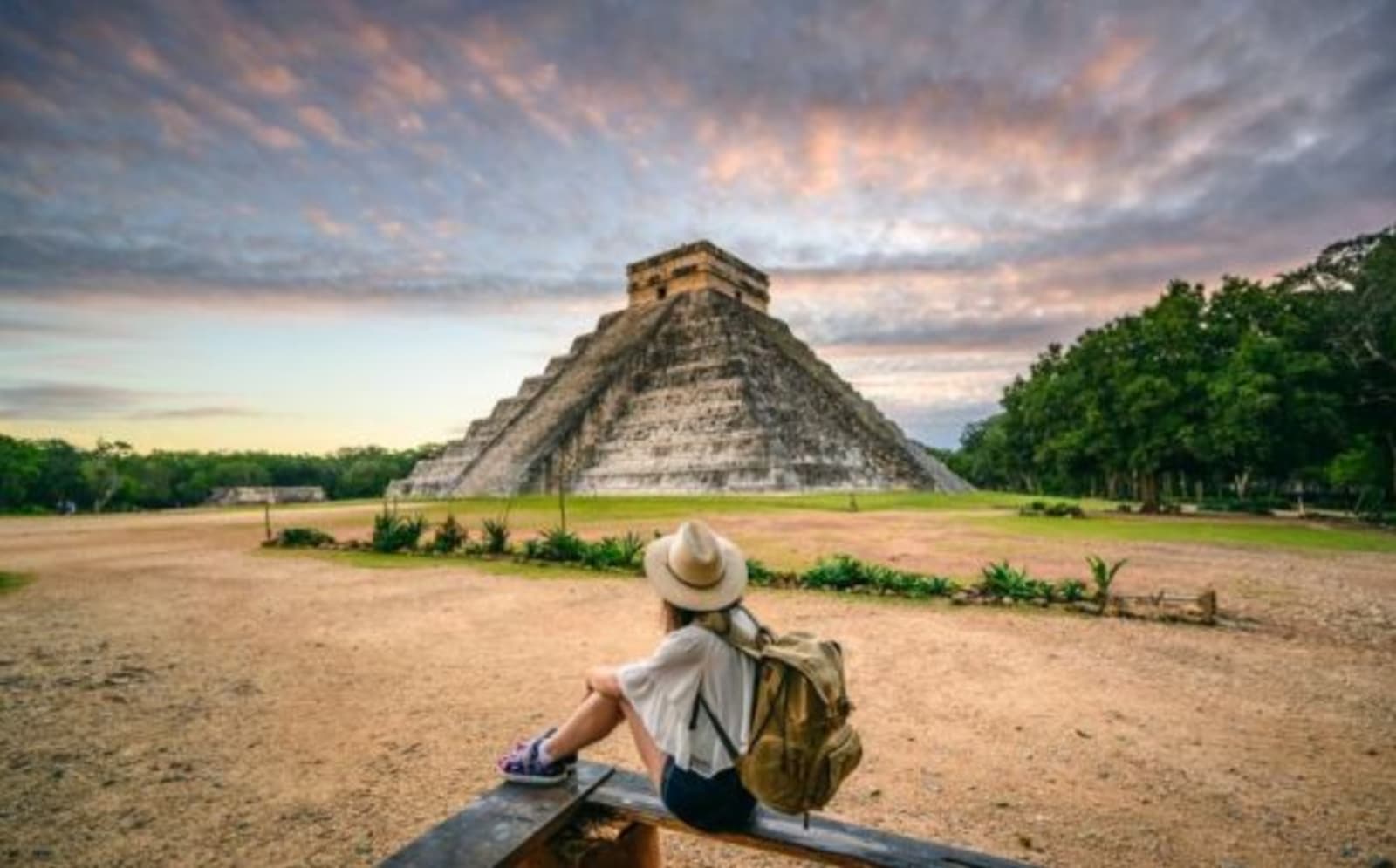 woman sitting infront of Mayan pyramid