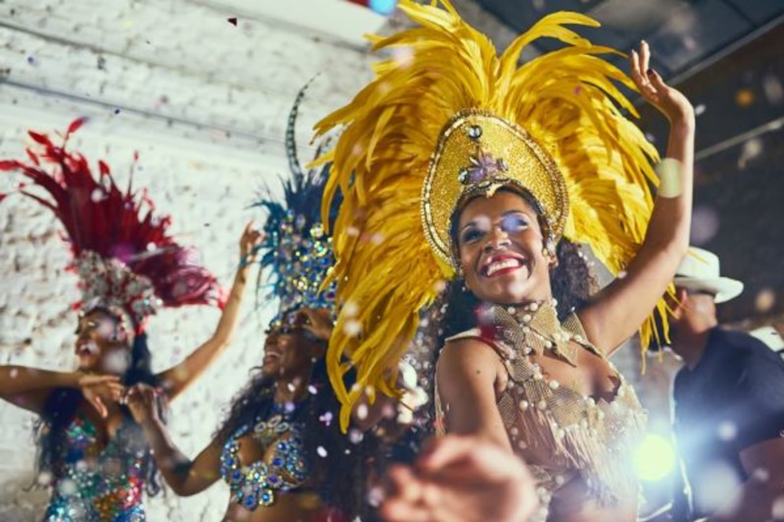 Dancers wearing colourful costumes during night life carnival with confetti falling
