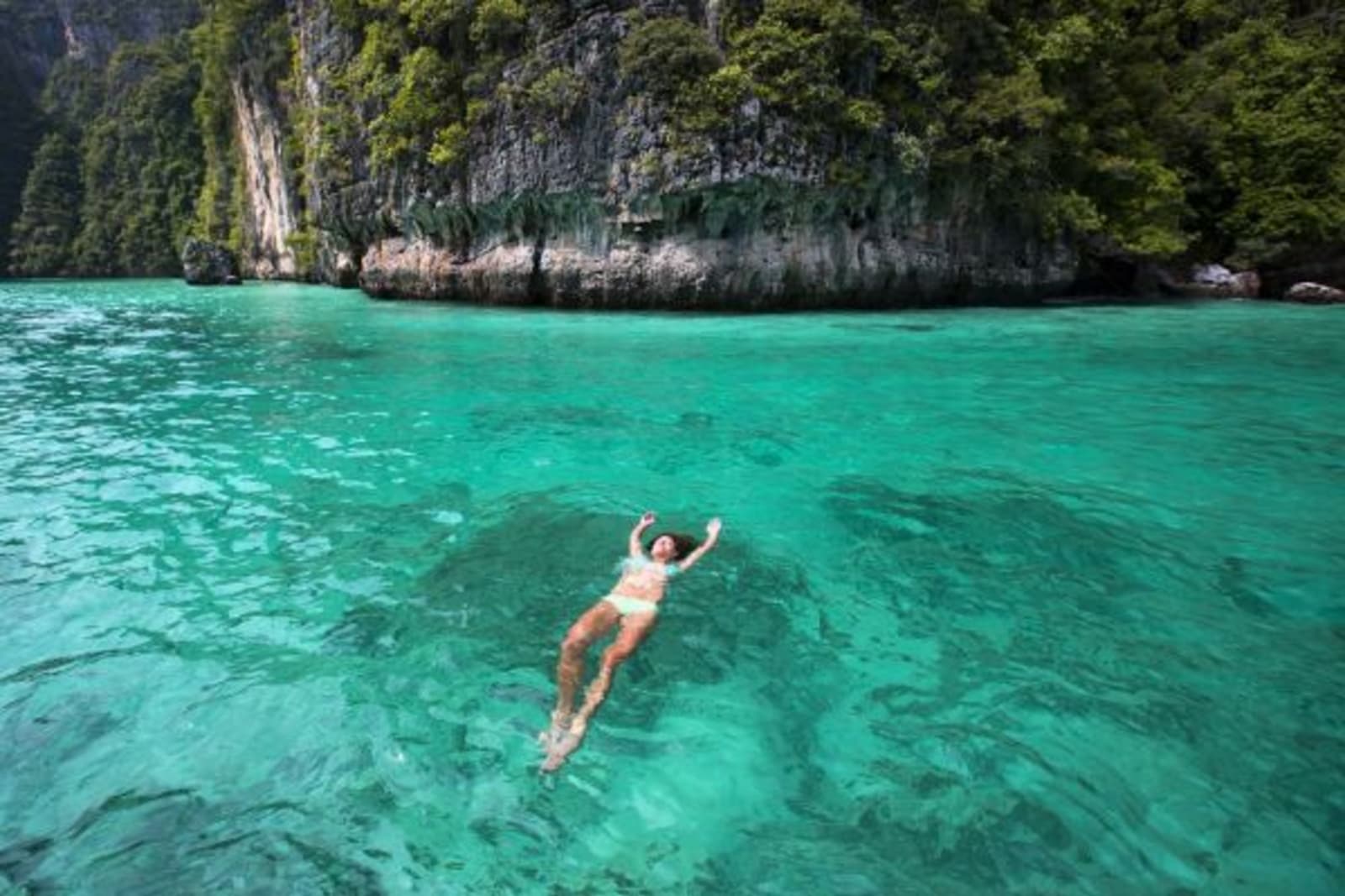 Female floating in crystal clear water