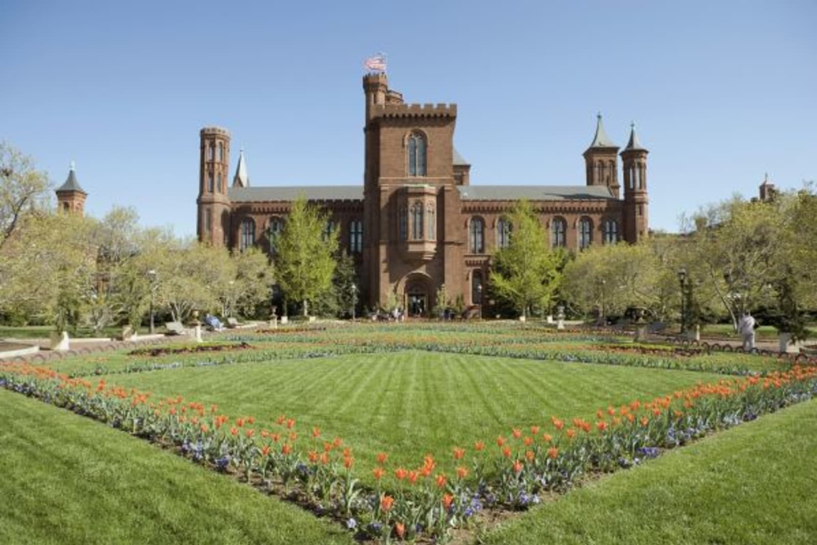 Red flowers in a square garden with Smithsonian in the background
