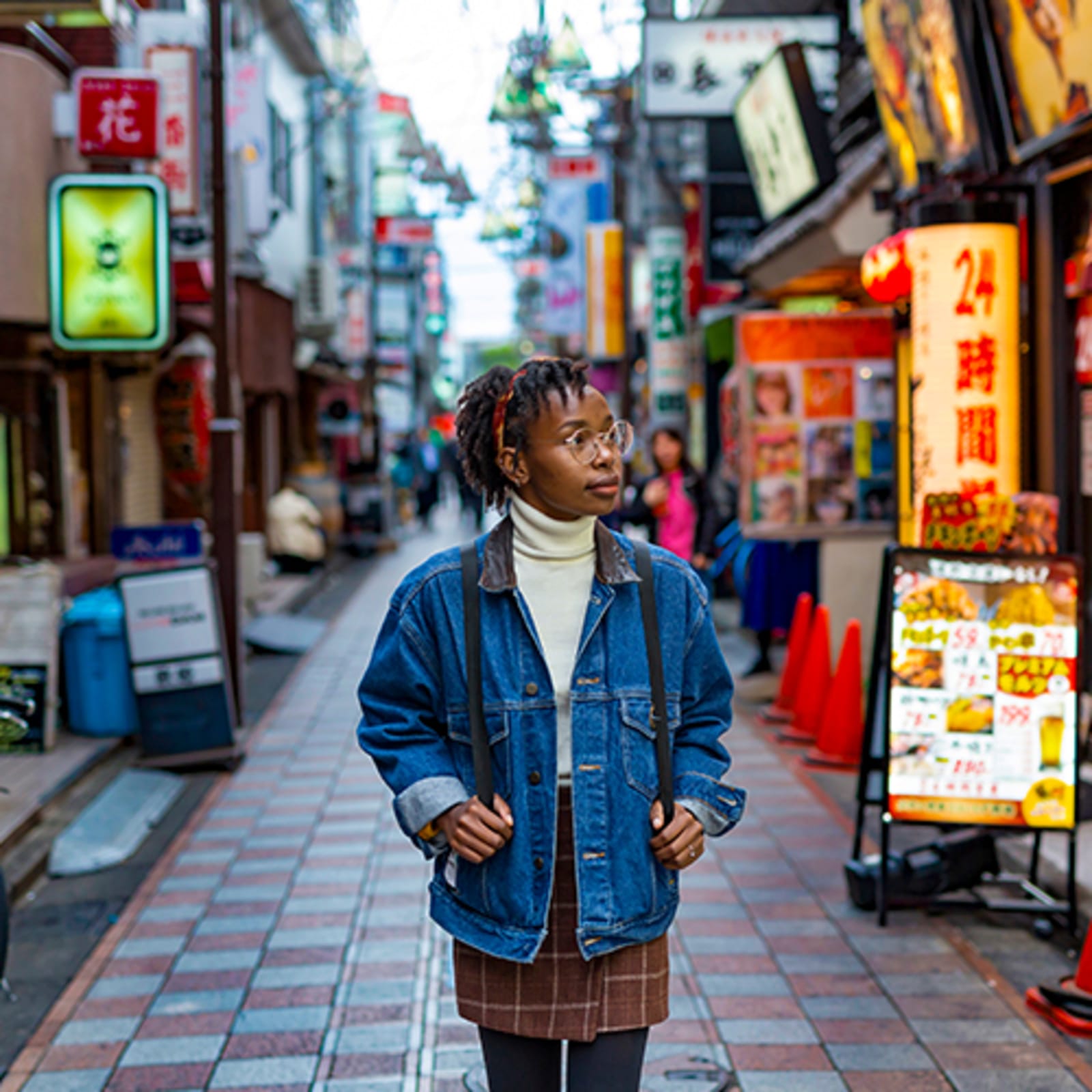 Woman walking down a neon-lit street in Japan