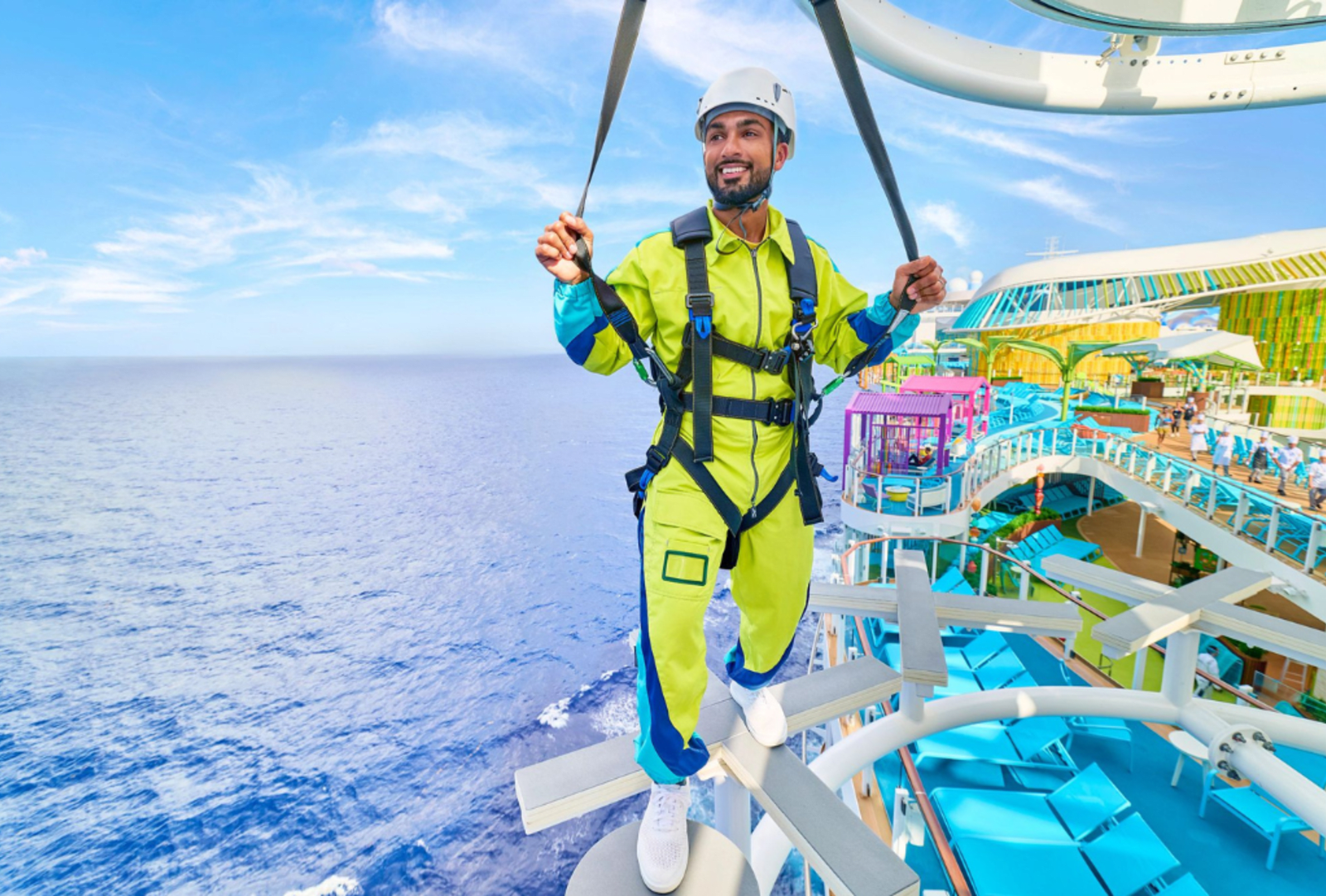 Man ziplining high above Icon of the Seas with colourful waterslides and pools spread out below